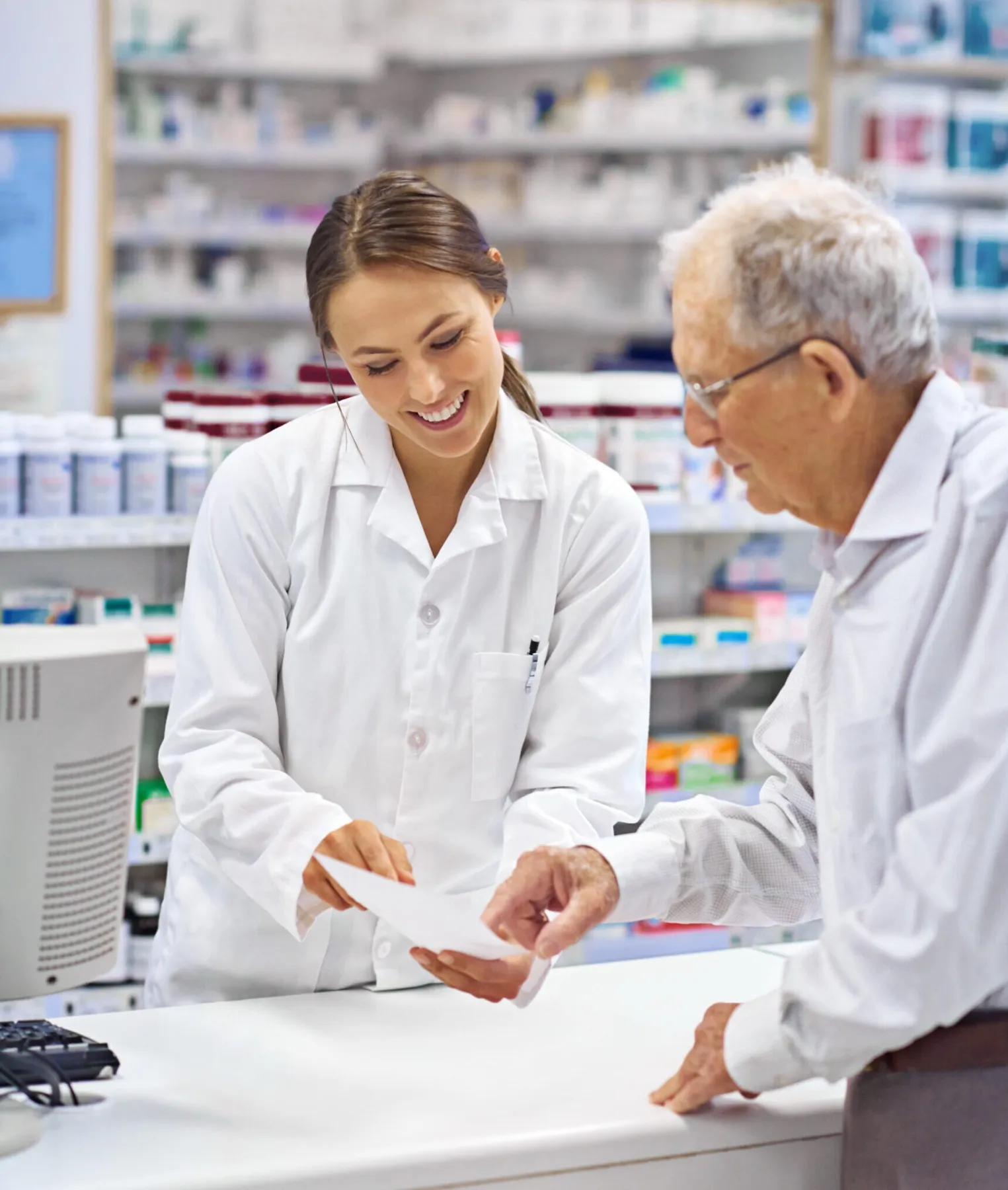 A patient points to a detail on a prescription that a pharmacist is holding
